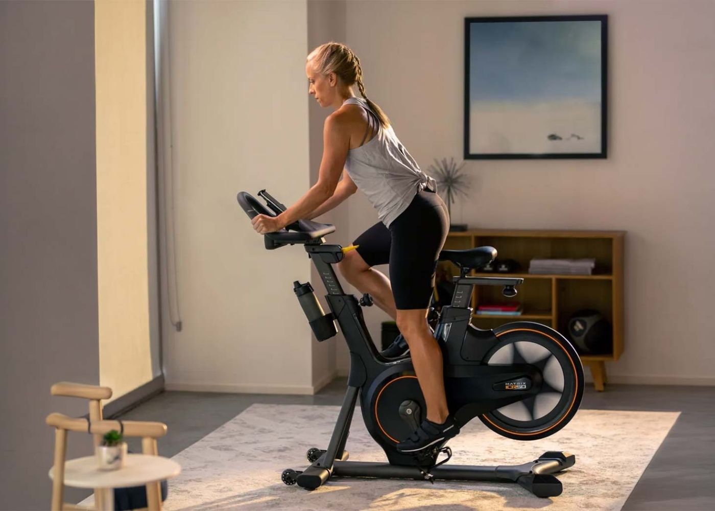 Žena cvičiaca doma na cyklotrenažéri Matrix ICR50