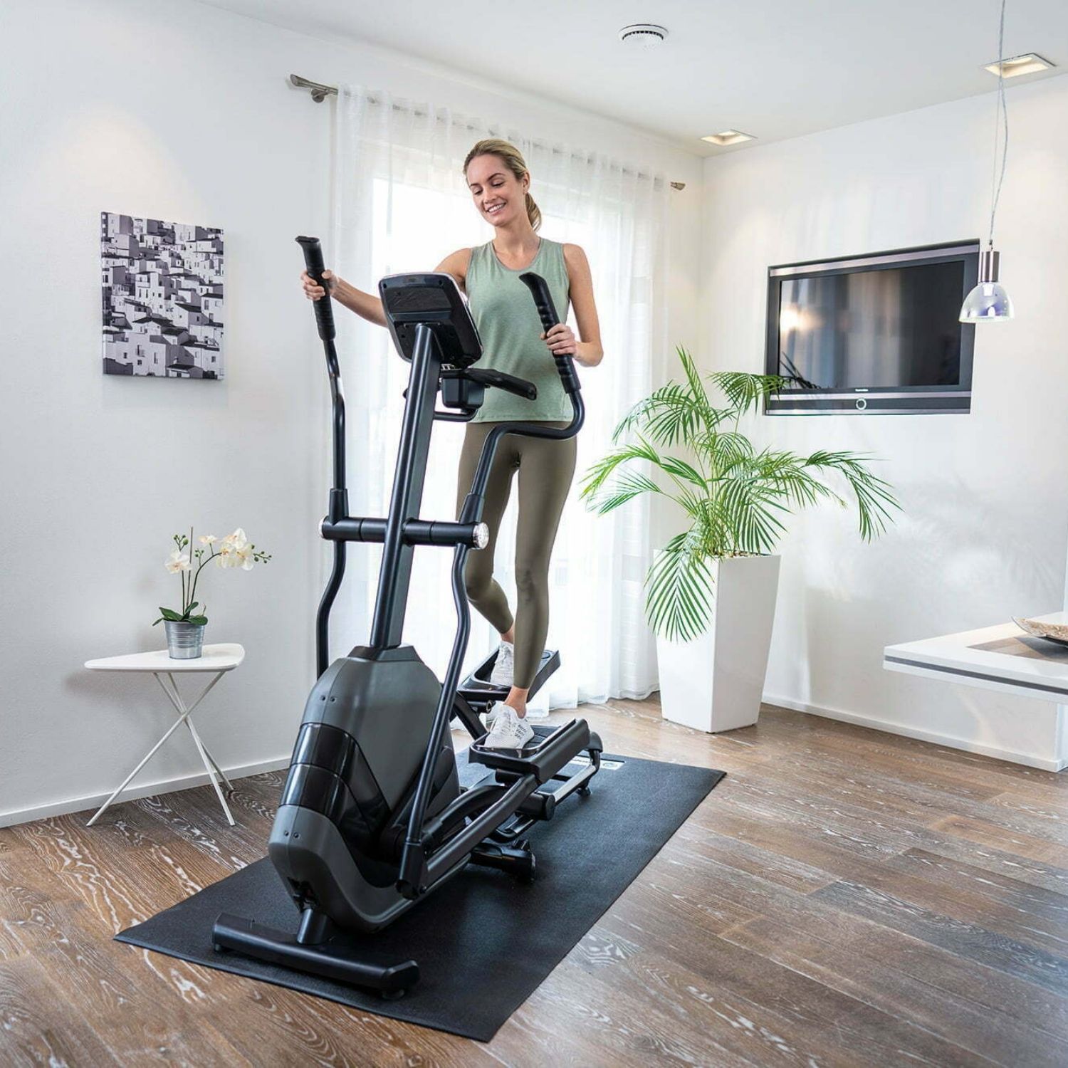 Žena cvičí na kompaktnom eliptikale Andes 7.1 v bežnom byte